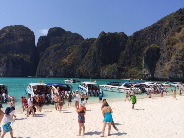 Barcos curtem um mar turquesa enquanto o pessoal observa do lado de fora